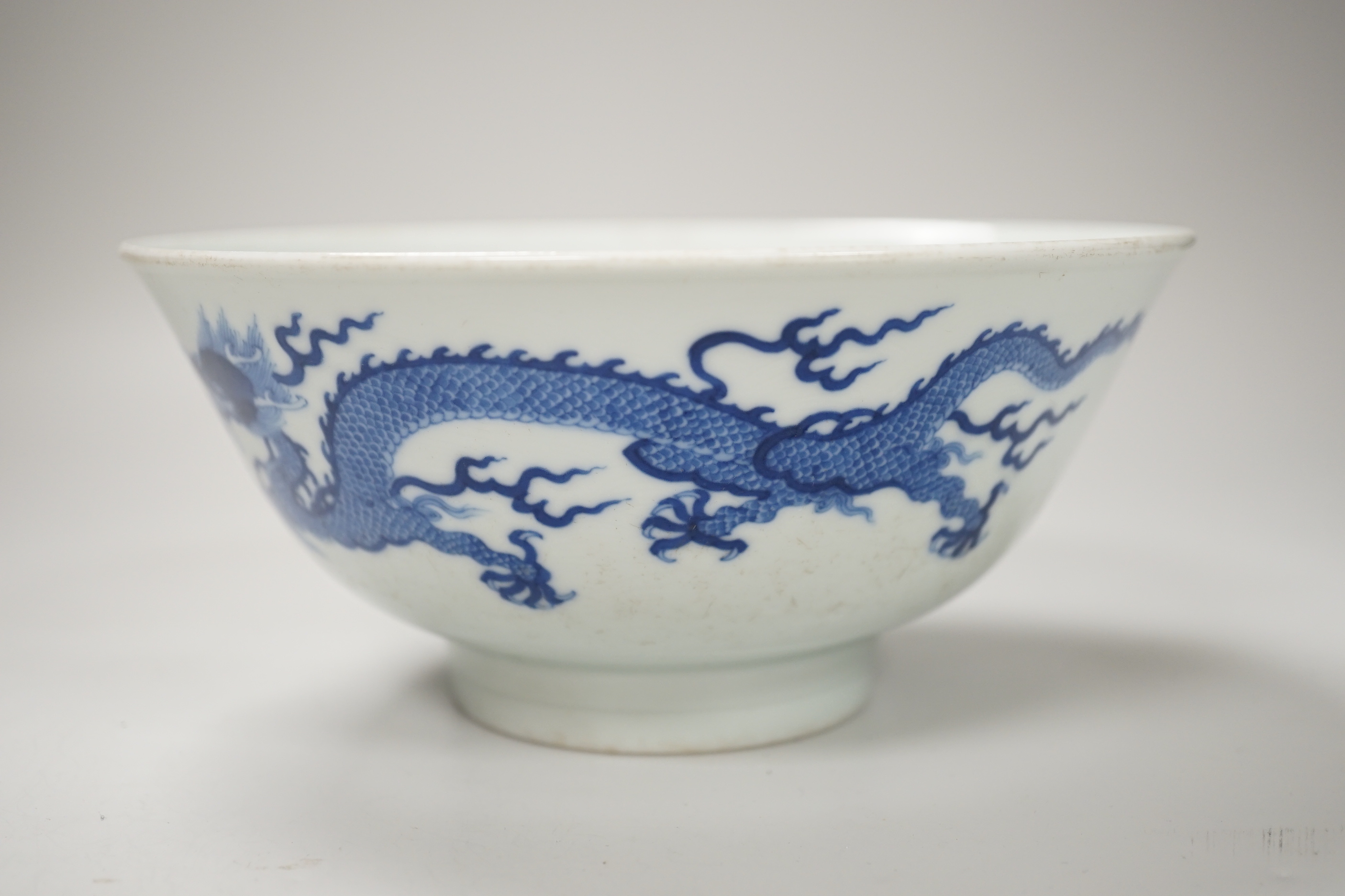 A Chinese blue and white bowl, hand painted with dragons, housed in a fitted case, 18cm in diameter